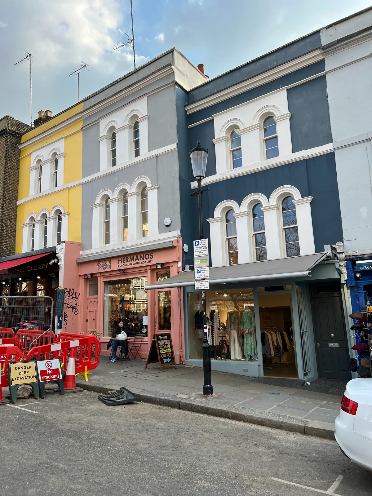 Hermanos Colombian Coffee Roasters cafe on 127 Portobello Road, Notting Hill — pink shopfront, Colombian flag, batch brew on the counter