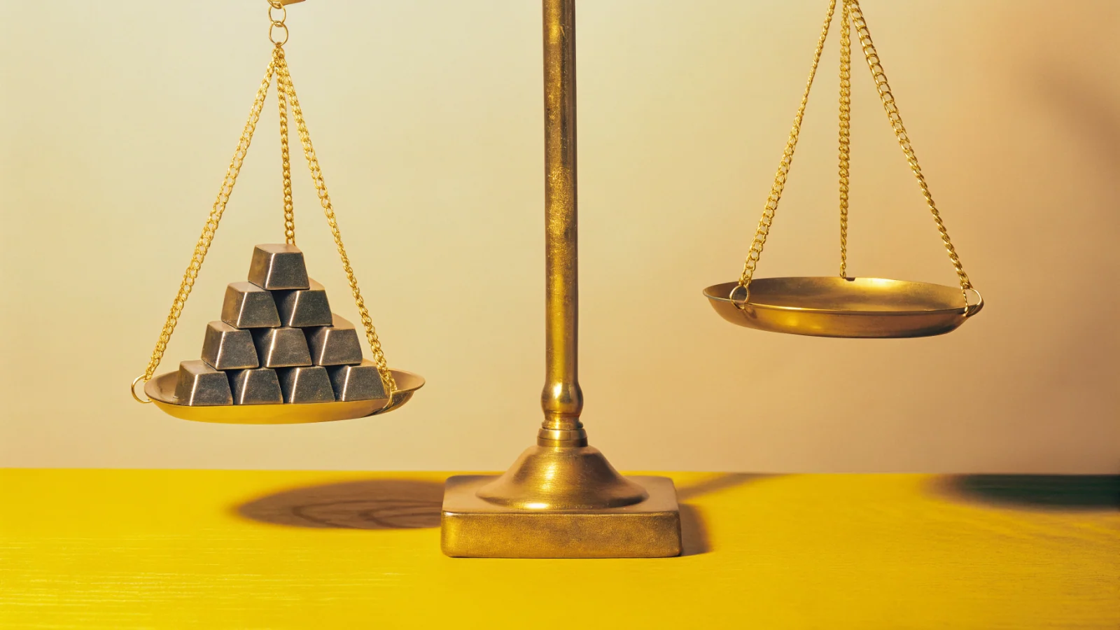A balance scale weighing geometric coin-like ingots against a rising organic-traffic line graph