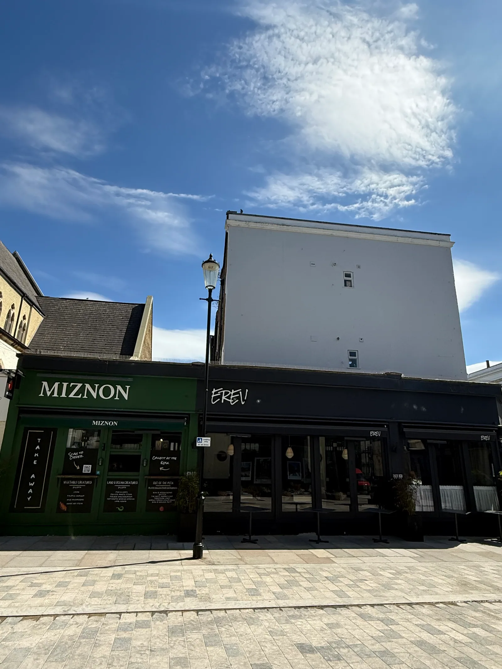 The Miznon and Erev storefront at 14 Elgin Crescent in Notting Hill, the dark green frontage of Eyal Shani's Israeli kiosk that runs Miznon for pitas by day and Erev for Levantine dinner by night